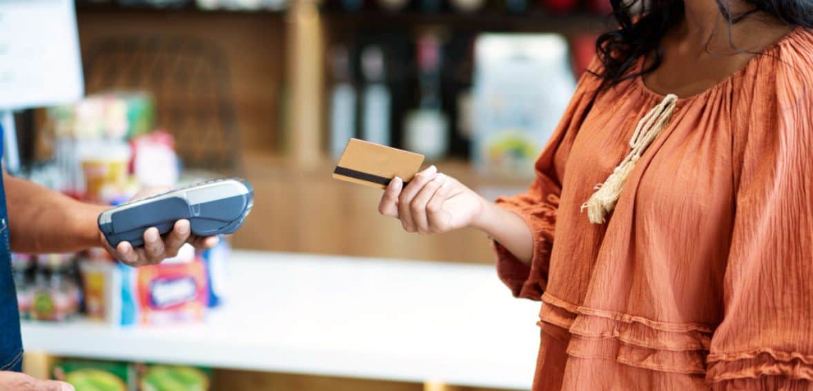 Woman paying with card at counter